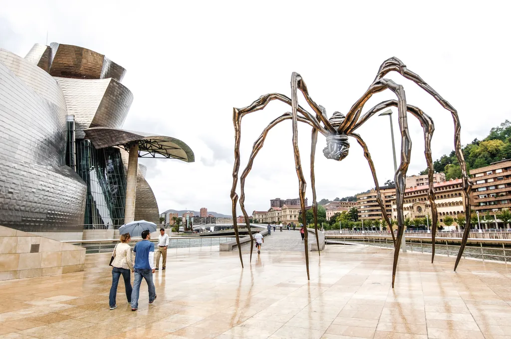 Giant spider metal sculpture with modern architecture